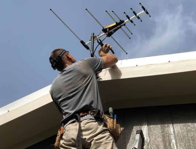 TV antenna installation on a suburban roof